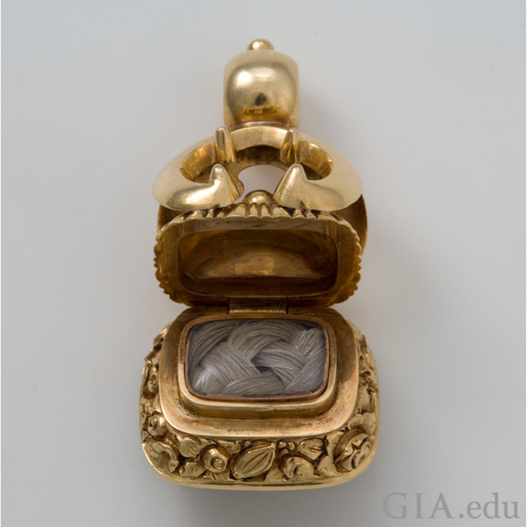 This Victorian watch fob opens to reveal plaited locks of human hair. The stone on its base is very dark, almost black. These features are typical of mourning jewelry. Photo: Valerie Power/GIA. Courtesy: Jana Miyahira-Smith