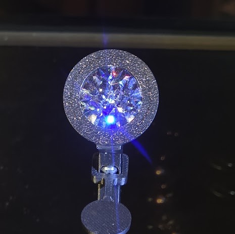 Close-up of a diamond illuminated with blue and white light, photographed at the 41st World Diamond Congress in Singapore.